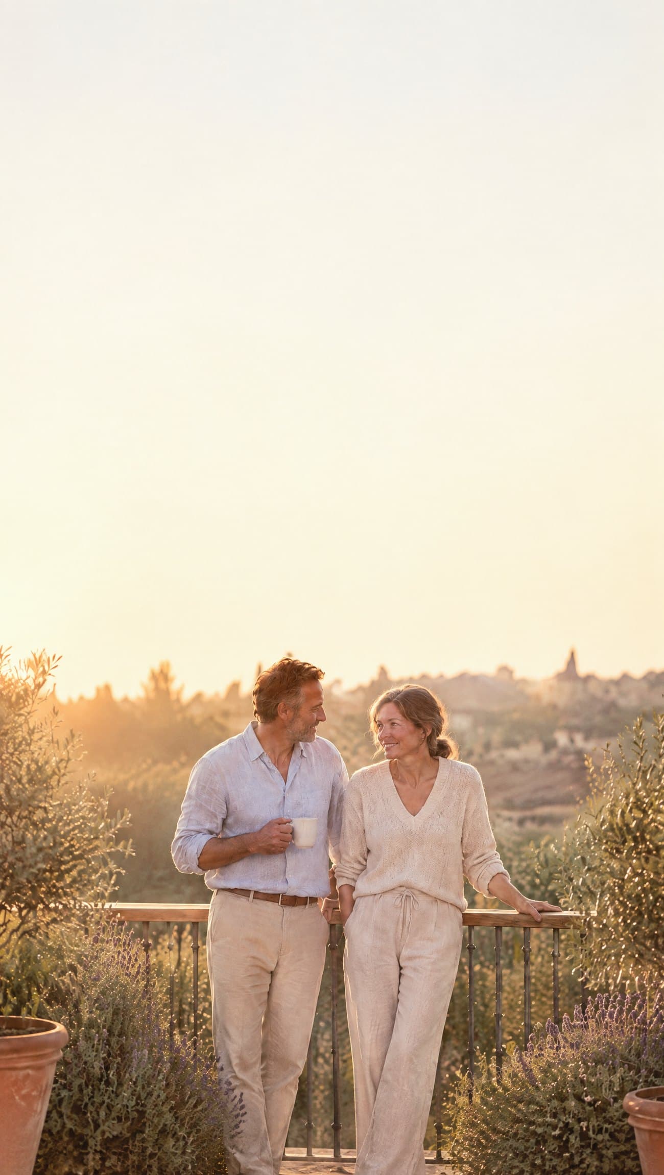 The same woman and her partner laughing together on their sunny terrace